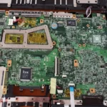 Diagnóstico e reparação de motherboard de portátil por Diogo Carvalho Informática, mostrando os componentes eletrónicos internos para análise técnica.