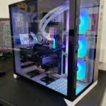 Montagem de um computador personalizado em caixa branca por Diogo Carvalho Informática, destacando a placa gráfica ASUS TUF e sistema de water cooler com iluminação RGB.